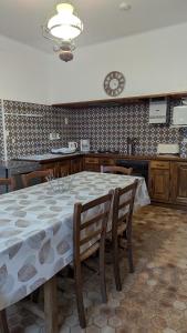 a dining room table with chairs and a clock on the wall at La maison du sabotier in Audressein
