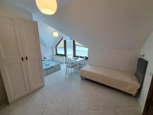 a bedroom with a bed and a dining room with a table at Willa Na Zboczu in Chmielno