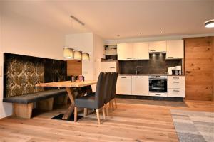 a large kitchen with a wooden table and chairs at Apartment Grubigstein in Biberwier