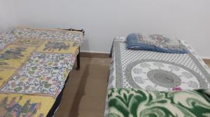 two beds sitting next to each other in a room at home stay IIIT chauraha near subedargunj railway station in Prayagraj
