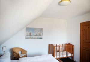 ein Schlafzimmer mit einem Bett und einem Kinderbett in der Unterkunft Bauernhof Höper-Rauert - Reihenhaus 8 in Neujellingsdorf + 14 Fotos