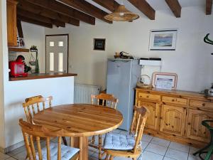 a kitchen with a wooden table and a refrigerator at Maison abelias soustons plage in Soustons