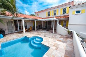 a swimming pool in front of a house at Sweet Home Grenada Caribbean in Lance aux Épines