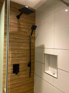 een badkamer met een douche en een spiegel bij Centurion Aparthotel in Abuja