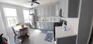 a kitchen with white cabinets and a table and chairs at Entire 3 bedrooms Apt,10sleepers ,15 mins to NYC in Jersey City +29 photos