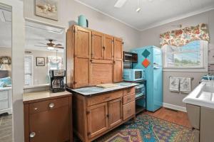 a kitchen with wooden cabinets and a blue refrigerator at Bue Crab Bungalow - Charming in-town cottage! in Birch Town