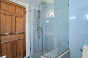 a glass shower in a bathroom with a toilet at Bue Crab Bungalow - Charming in-town cottage! in Birch Town +17 photos