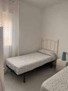 una camera da letto con due letti in una stanza di PISO CENTRO HISTÓRICO 3 DORMITORIOS a Jerez de la Frontera