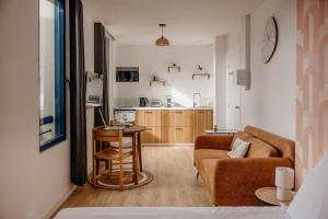 a living room with a couch and a table at Le Nid du Clocher in Guichen