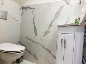 ウェスト・サロックにあるElevate your stay with Sai homeのトイレと洗面台を備えた白いバスルーム +28枚の写真