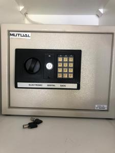 a microwave oven with a remote control on top of it at Listening Wind Self-Catering accommodation in Bettyʼs Bay