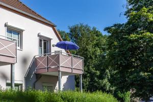 una persona con un ombrello blu seduta su un balcone di Ferienwohnung "Strandgut" a Neuhaus