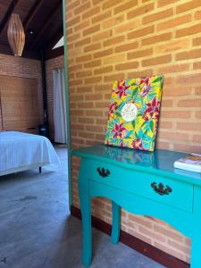 a pillow sitting on a blue table next to a wall at Chalés Villa Serrinha - Chalé 01 in Bueno Brandão +18 photos
