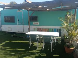 a table and chairs in front of a trailer at KairamSurf in El Palmar