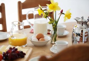 einem Tisch mit Eiern und einem Krug Orangensaft und Blumen in der Unterkunft Bauernhof Höper-Rauert - Reihenhaus 4 in Neujellingsdorf
