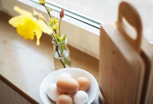 eine Schüssel mit Eiern und eine Vase mit Blumen in der Unterkunft Bauernhof Höper-Rauert - Reihenhaus 4 in Neujellingsdorf