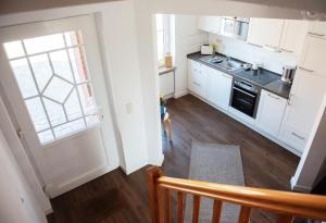 eine Küche mit weißen Schränken und einem Holzboden in der Unterkunft Bauernhof Höper-Rauert - Reihenhaus 4 in Neujellingsdorf