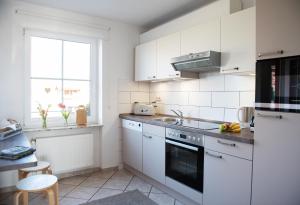 eine Küche mit weißen Geräten und einem Fenster in der Unterkunft Bauernhof Höper-Rauert - Reihenhaus 6 in Neujellingsdorf