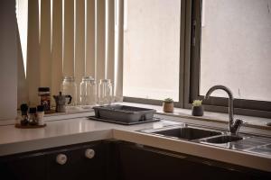 a kitchen counter with a sink and a window at Seafront condo with a view of Valletta in Il-Gżira taʼ Forti Manoel +11 photos
