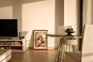a living room with a table and a picture of a chicken at Seafront condo with a view of Valletta in Il-Gżira taʼ Forti Manoel
