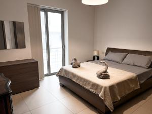 a bedroom with a bed with two snakes on it at Seafront condo with a view of Valletta in Il-Gżira taʼ Forti Manoel