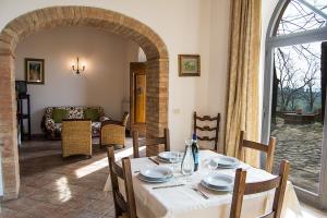 una sala da pranzo con tavolo, sedie e arco di Agriturismo Torraiolo a Barberino di Val dʼElsa