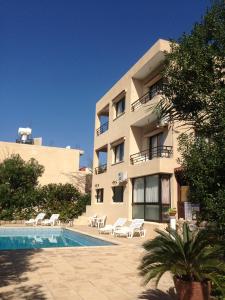 um edifício com piscina em frente a um edifício em Panklitos Tourist Apartments em Pafos