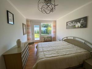 a bedroom with a bed and a table and a window at Ferienhaus direkt an der Luhe in Winsen Luhe