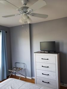 1 dormitorio con ventilador de techo y vestidor con TV en Beach House, en York