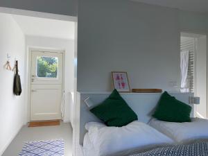 a bedroom with a bed with green pillows on it at Nije Haven Bed & Breakfast in Wrixum