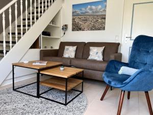 a living room with a couch and a table at Wohnung Ankerplatz in Wrixum