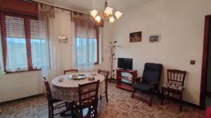 a dining room with a table and chairs and a television at Fabia's House in Tertenìa