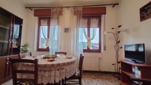a dining room with a table and a television at Fabia's House in Tertenìa