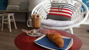 a table with a drink and a plate with a croissant on it at Hotel Xaine Park in Lloret de Mar