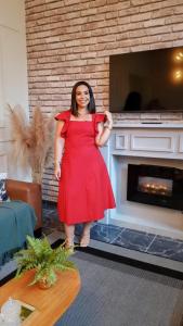 a woman in a red dress standing in front of a fireplace at Casa Naza in Areia +34 photos