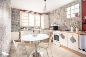 a kitchen with a table and chairs in a room at Exceptional beach sea view in Plestin-les-Grèves +33 photos