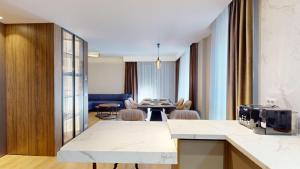 eine Küche und ein Wohnzimmer mit Tisch und Stühlen in der Unterkunft Quiet Luxury Home 2 - home & office in Zalău