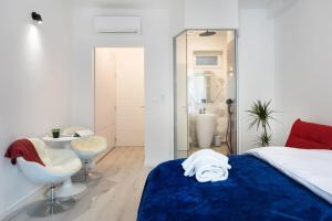 a bedroom with a bed and a chair and a bathroom at Lux Nest II City Apartment URBAN STAY in Zagreb