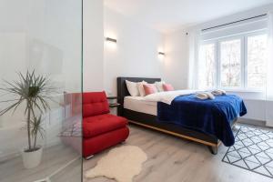 a bedroom with a bed and a red chair at Lux Nest II City Apartment URBAN STAY in Zagreb +21 photos
