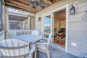 a patio with a table and chairs on a porch at Charlie's Bayside Retreat - Pet friendly, In town! in Chincoteague