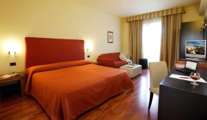 a hotel room with a bed and a chair at Hotel Cristallo di La Rosetta Srl in Assisi