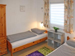 une chambre avec deux lits et une fenêtre dans l'établissement Ferienhaus Nr 134, Kategorie Komfort, Feriendorf Hochbergle, Allgäu, à Lechbruck am See 8 autres photos