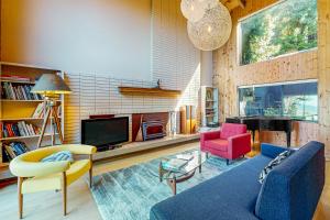 ein Wohnzimmer mit einem Sofa und zwei Sesseln und einem Fernseher in der Unterkunft Moonraker in Sea Ranch