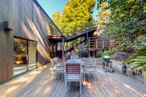 eine Holzterrasse mit einem Tisch und Stühlen darauf in der Unterkunft Moonraker in Sea Ranch