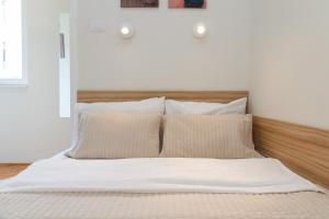 a bedroom with a bed with white sheets and pillows at City Break Apartments Klishe Zen in Belgrade
