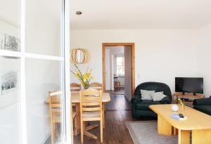 ein Wohnzimmer mit Tisch und Couch in der Unterkunft Bauernhof Höper-Rauert - Reihenhaus 2 in Neujellingsdorf