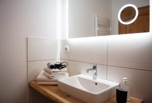 ein Badezimmer mit Waschbecken, Spiegel und Handtüchern in der Unterkunft Bauernhof Höper-Rauert - Reihenhaus 2 in Neujellingsdorf + 12 Fotos