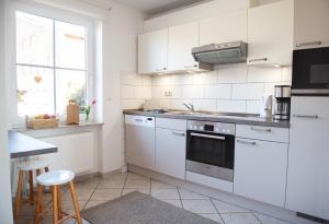 eine Küche mit weißen Schränken und einem Herd mit Backofen in der Unterkunft Bauernhof Höper-Rauert - Reihenhaus 7 in Neujellingsdorf