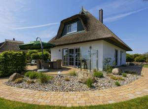 ein kleines Haus mit einem Strohdach in der Unterkunft Villa Sorgenfrei - a65549 in Zinnowitz