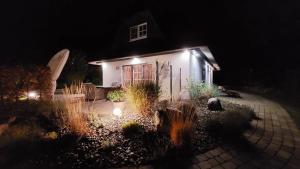 ein kleines weißes Haus mit Lichtern in der Nacht in der Unterkunft Villa Sorgenfrei - a65549 in Zinnowitz